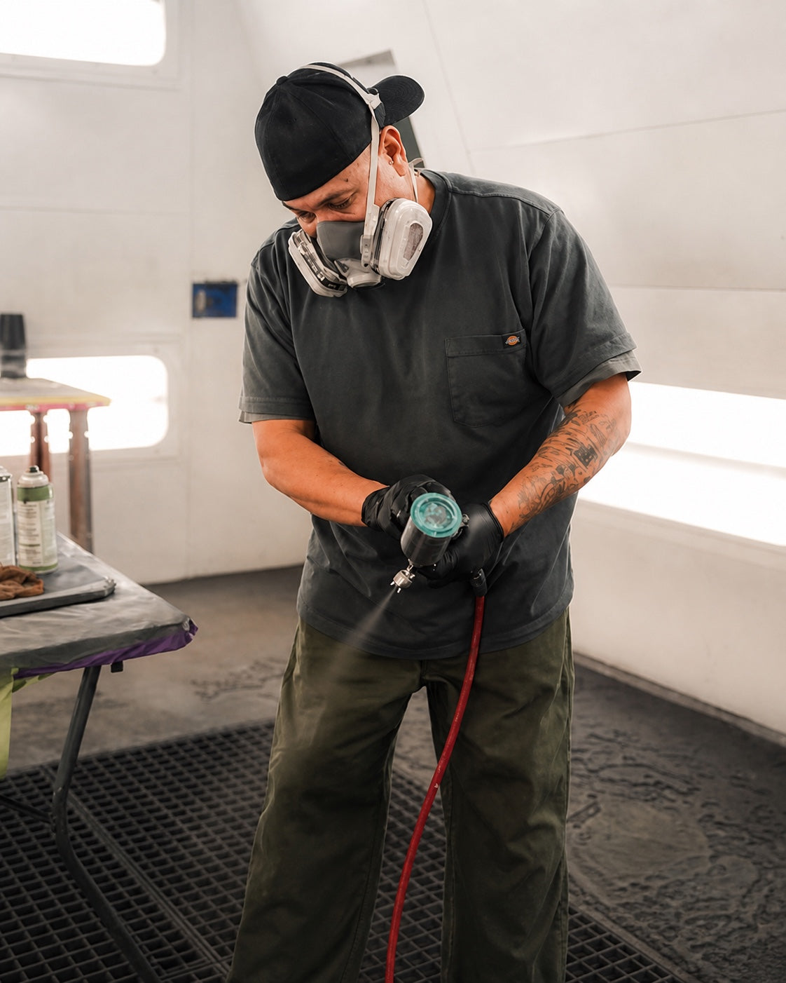 Tradesman wearing a dark work shirt in a paint booth